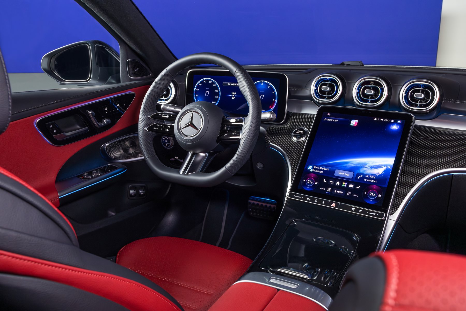 Puesto de conducción del nuevo Mercedes Clase C con el cuadro digital de 12,3 pulgadas, la pantalla central vertical de 11,9 pulgadas y asientos con tapicería roja